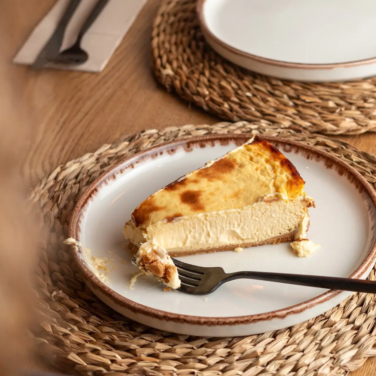 A slice of Basque burnt cheesecake on a plate with a fork