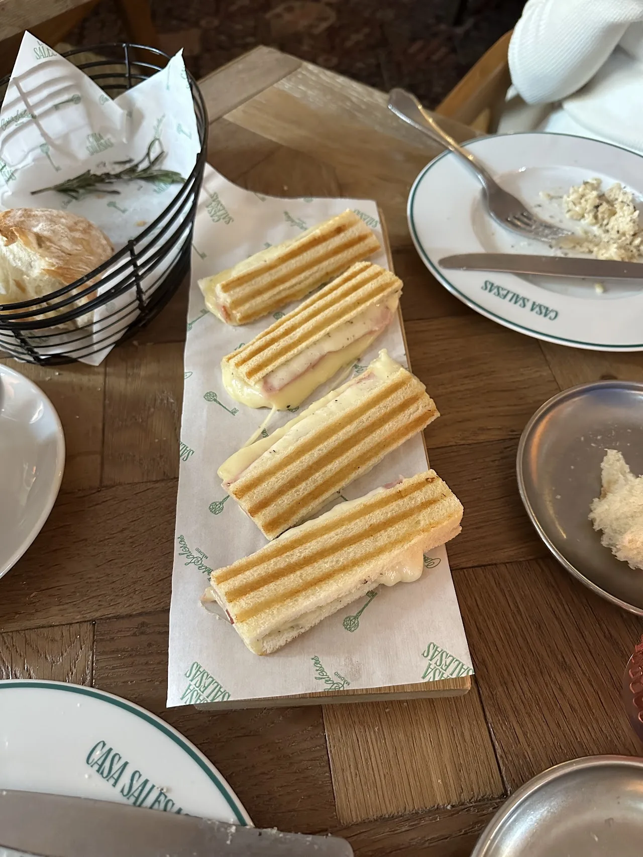 A row of toasted club sandwiches on a wooden board