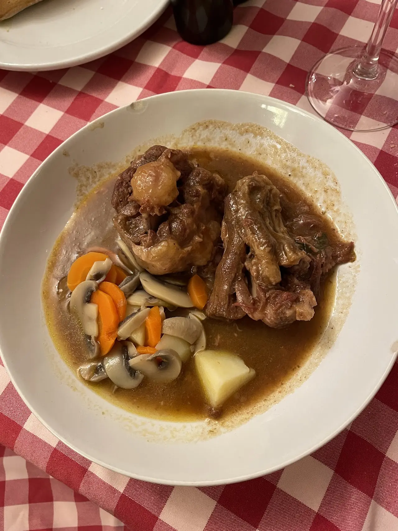 A braised meat stew with mushrooms and carrots in a rich brown sauce.