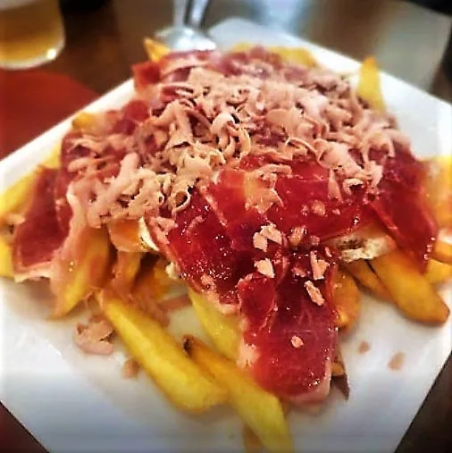 A plate of jamon iberico shavings over fries