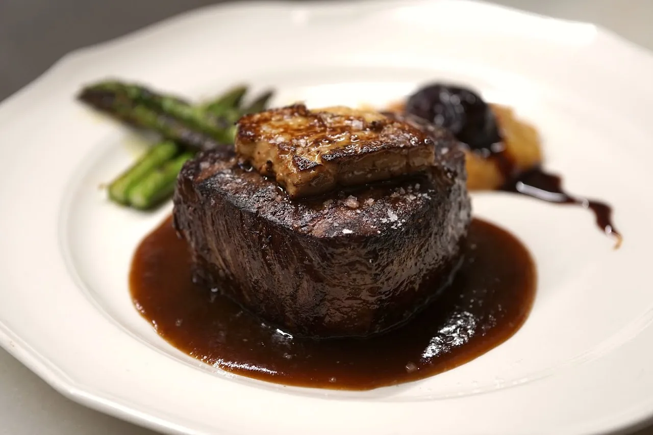 A seared filet steak with asparagus in a red wine reduction