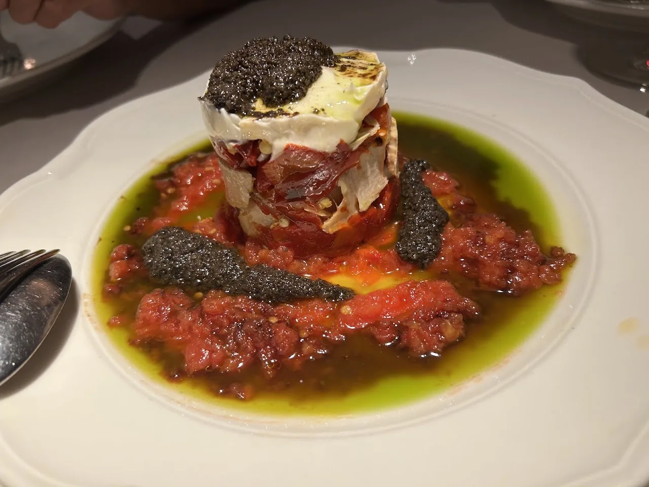 A tower of tomato and cheese with shaved black truffle