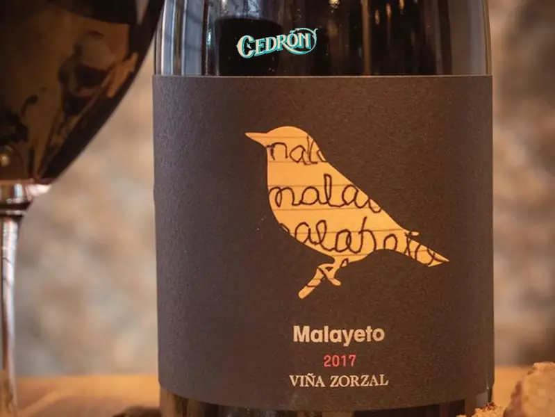 Bottle of Malayeto 2017 red wine labeled Cedron beside a poured glass of red wine