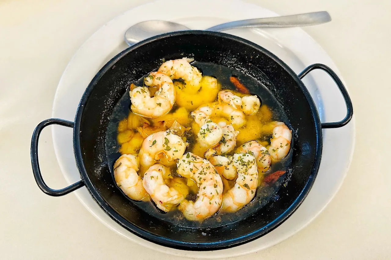 Garlic shrimp in a black pan with olive oil