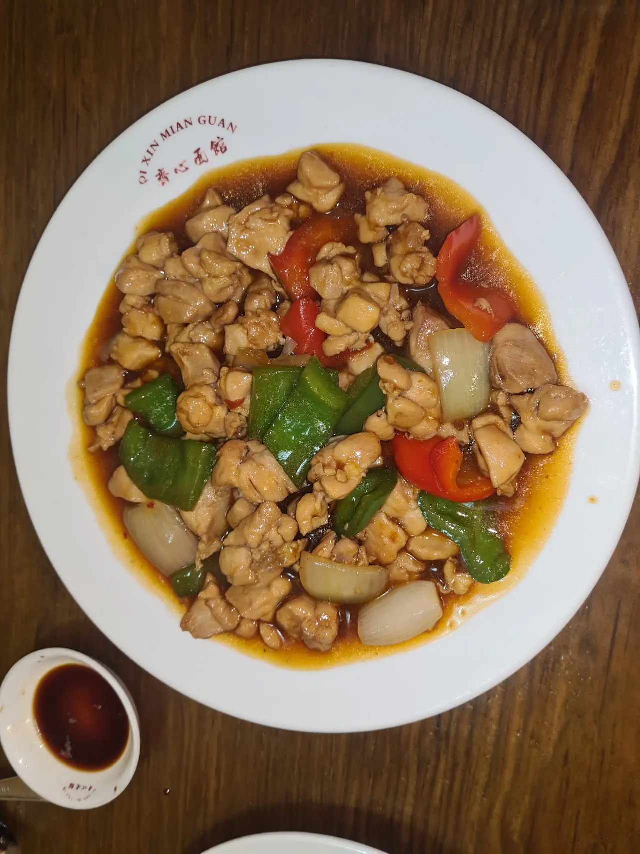 Diced chicken stir-fried with peppers in a savory sauce on a white plate, at Chen Ji.
