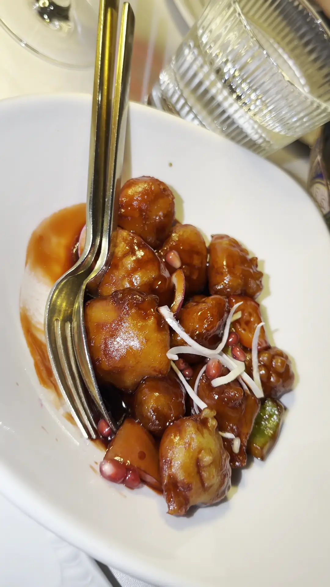 Stir-fried meat pieces in a glossy sauce with bean sprouts on a white plate.