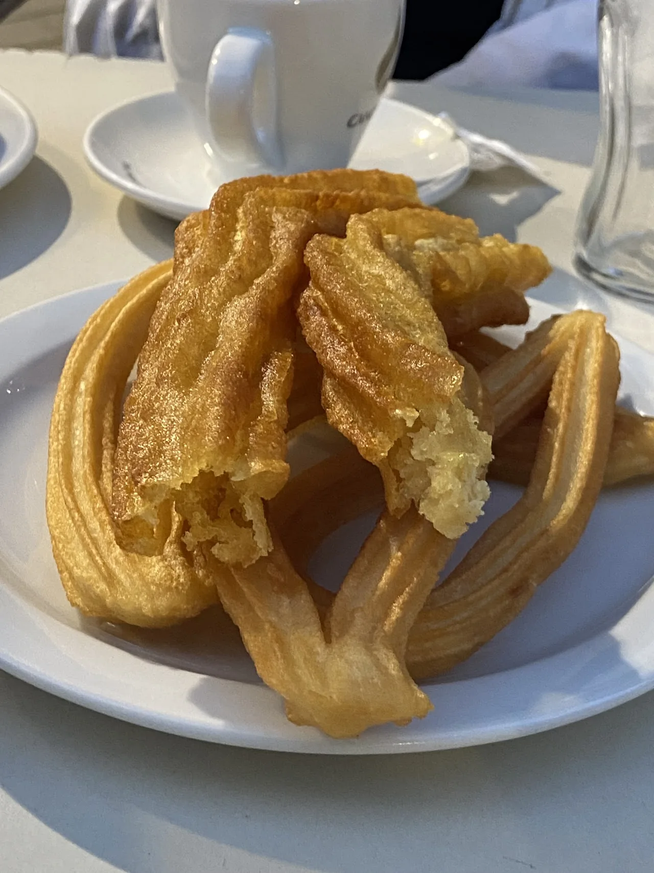 A plate stacked high with freshly fried churros