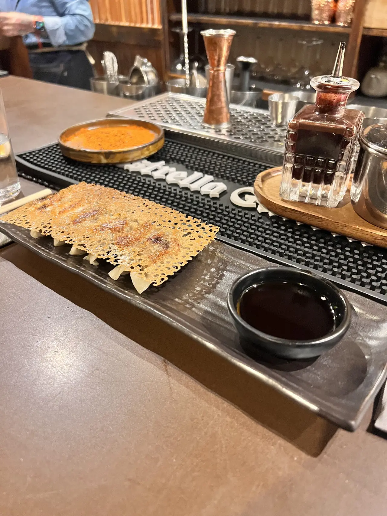 Crispy lace-edged pan-fried dumplings on a plate with a dipping sauce bowl