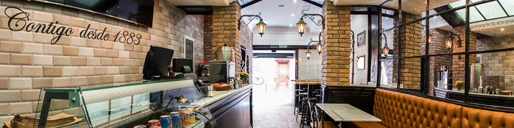 The chocolatería's dining room interior with a counter, display case and seating