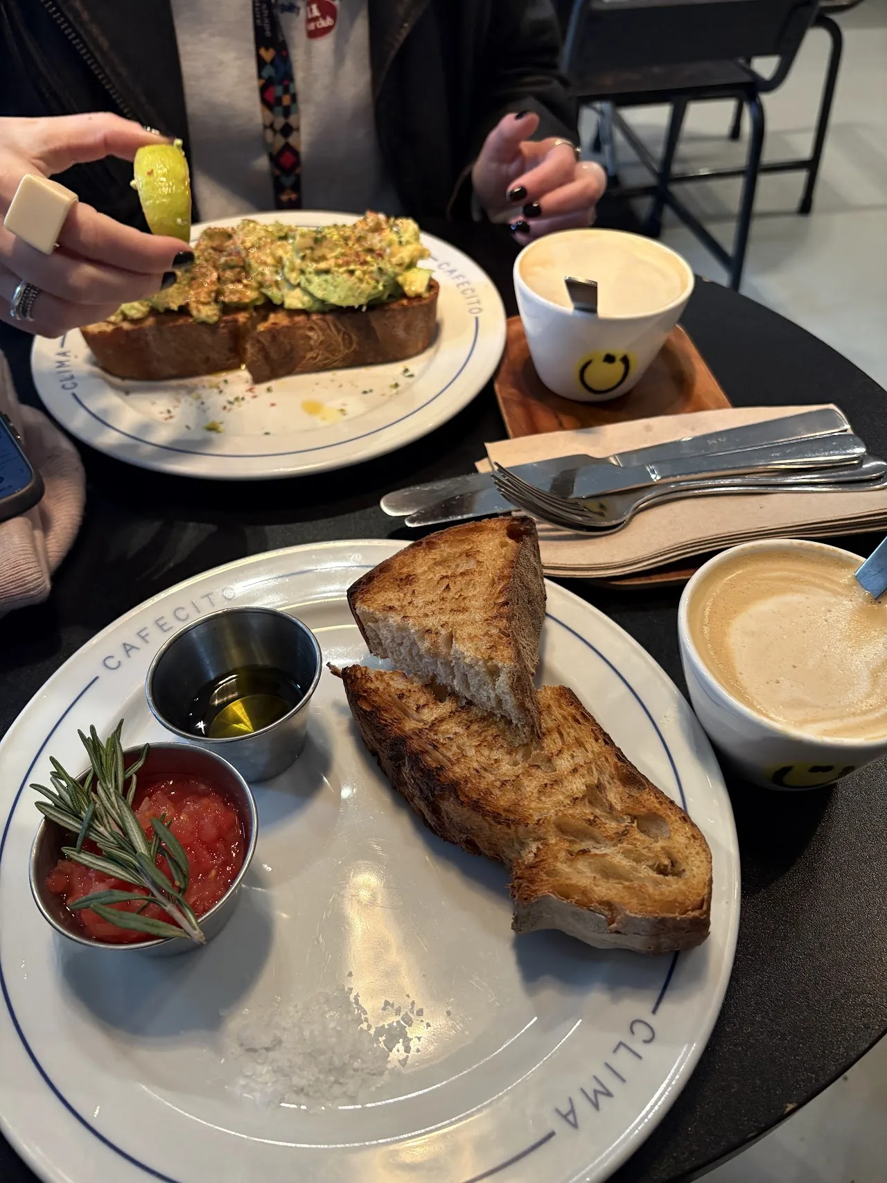 A table spread with grilled toast, small dips, and a cup of coffee