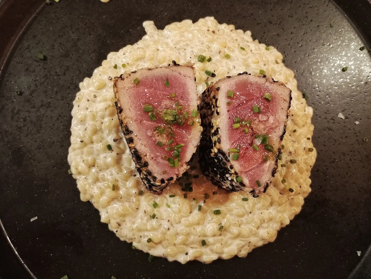 Seared tuna slices with a sesame crust served over creamy risotto