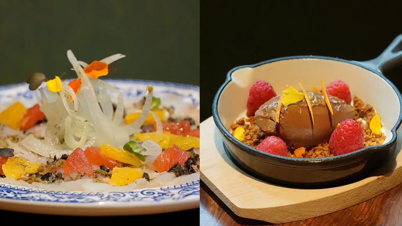 Two dishes side by side: a white-fish crudo with citrus segments, shaved fennel and edible flowers on a blue-rimmed plate, and a chocolate mousse quenelle with raspberries and crumble in a cast-iron pan