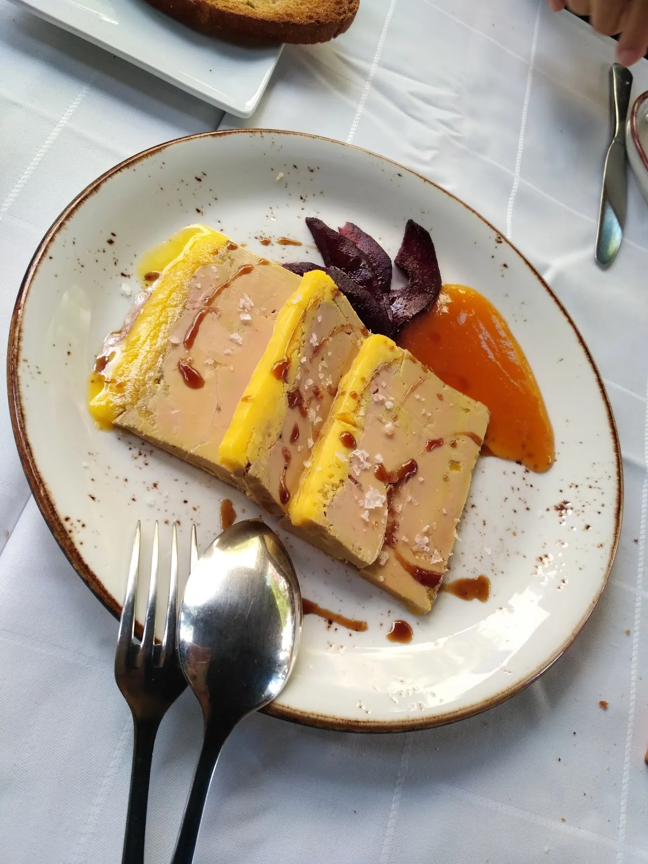 A layered terrine slice with a drizzle of sauce