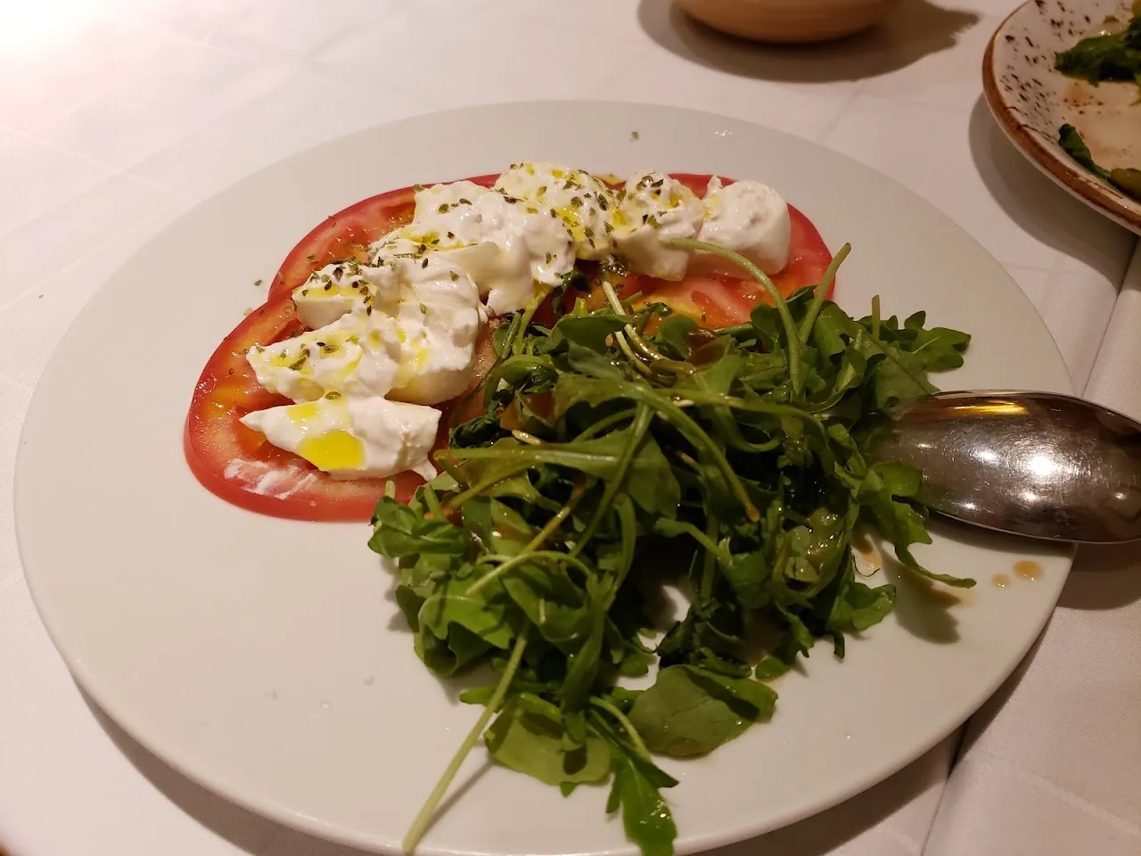 A burrata salad with tomato and arugula
