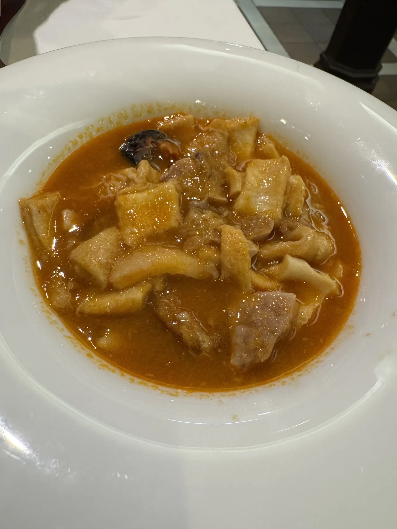 A stew of fish and potatoes in an orange broth
