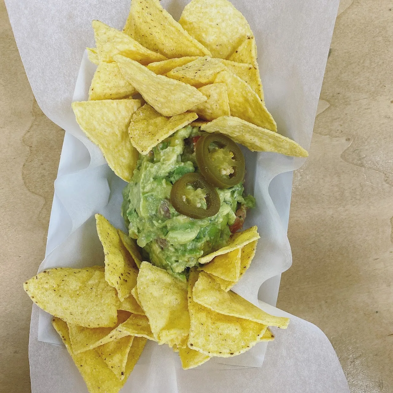 Tortilla chips served with guacamole and pickled jalapeños