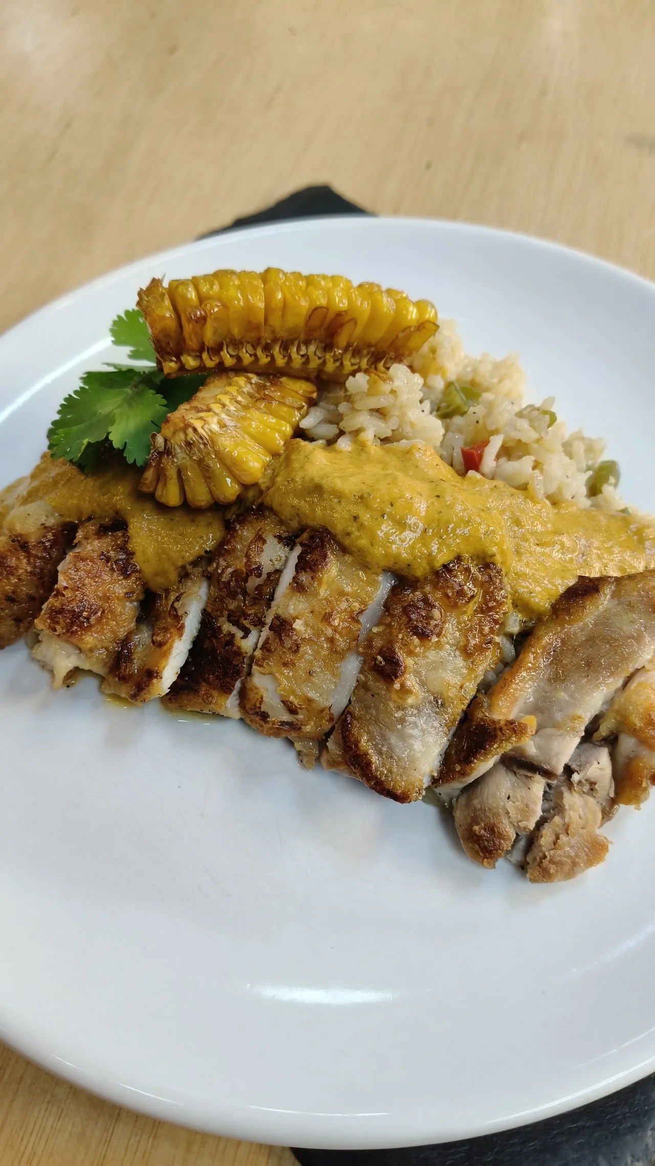 Fried chicken pieces served with grilled corn on a plate
