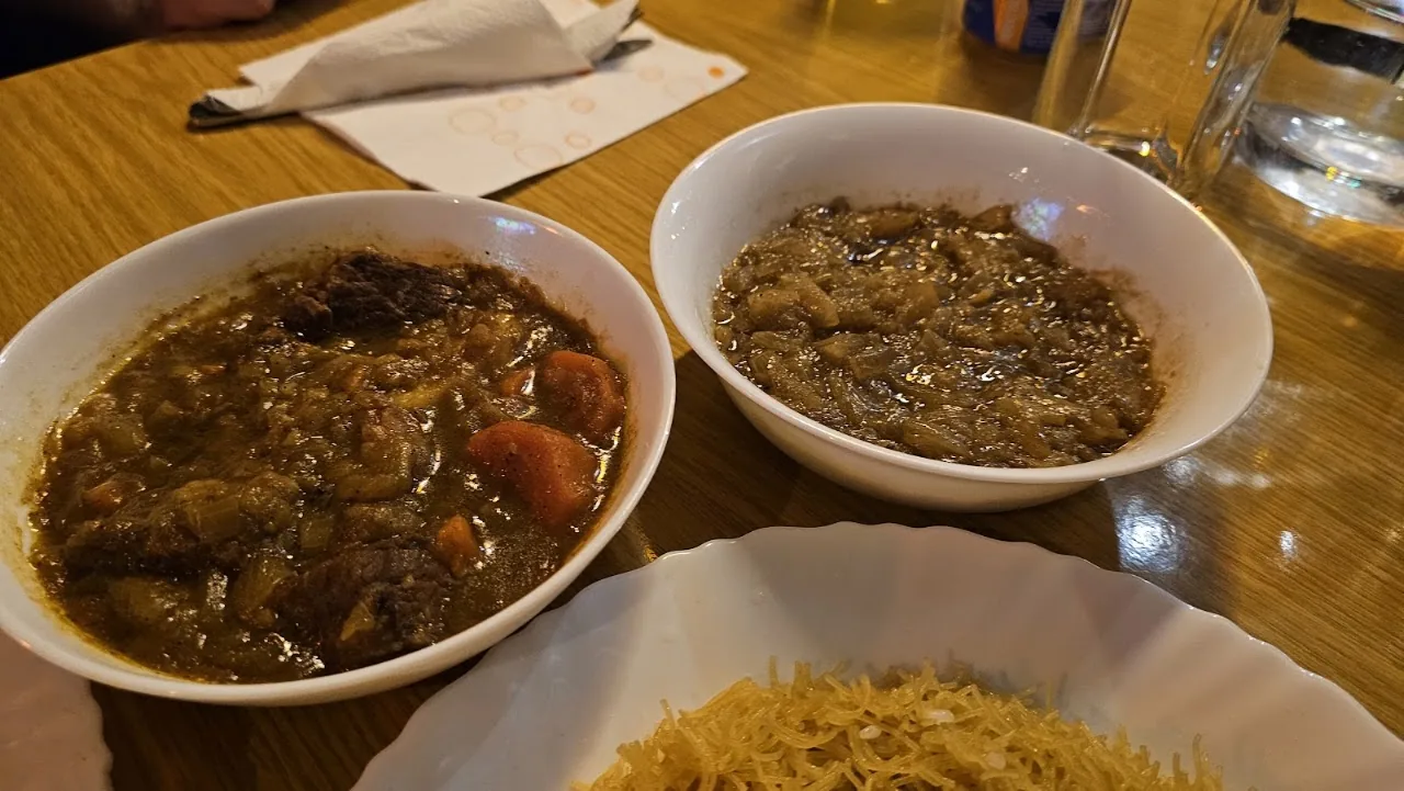 Two bowls of West African stew served with rice