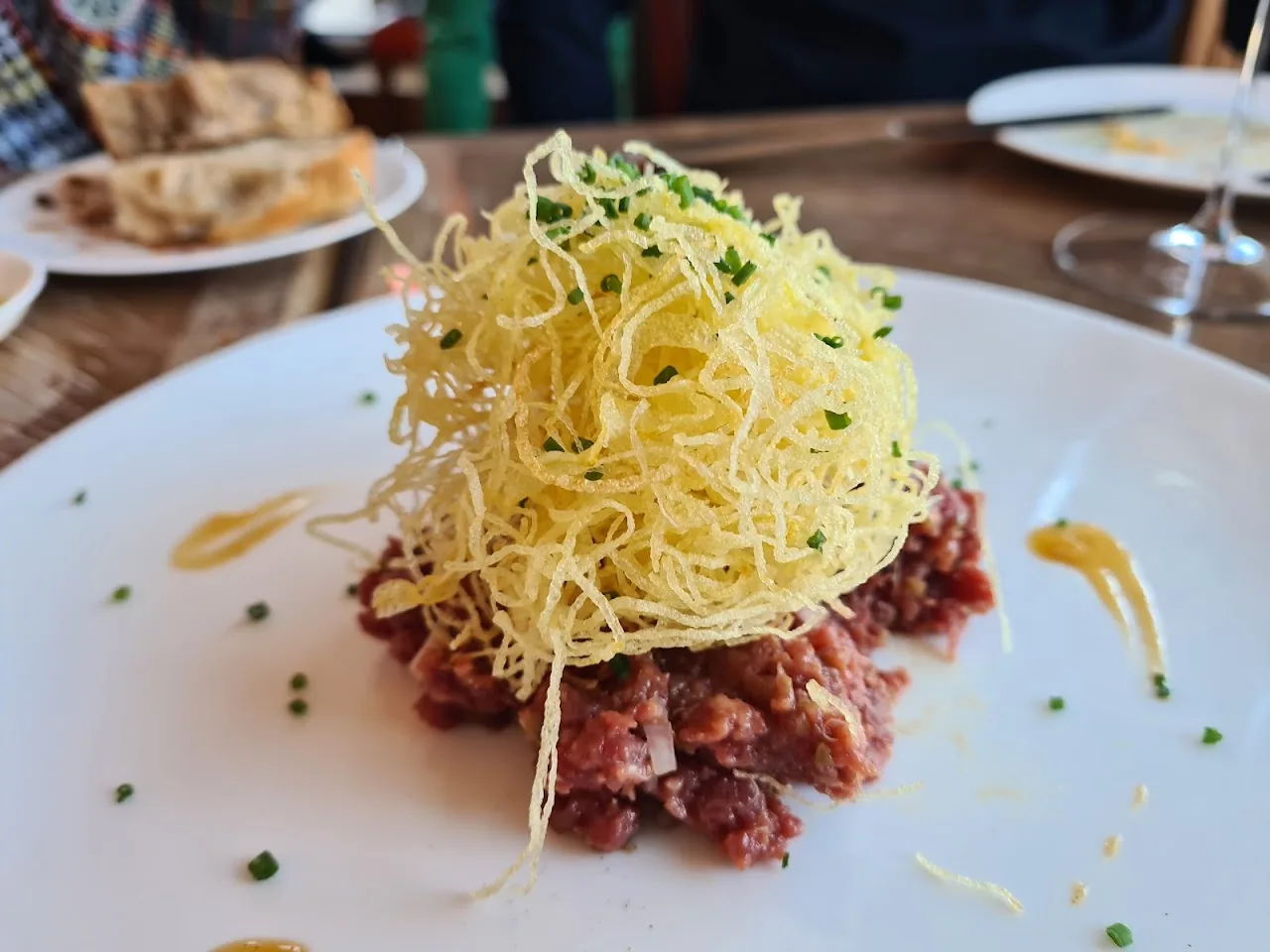 A mound of steak tartare topped with crispy shoestring fries