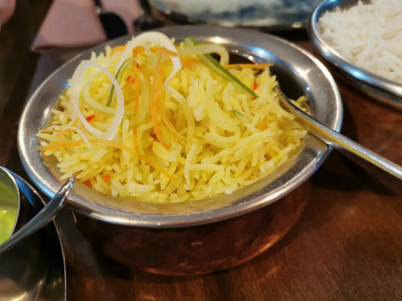 A metal bowl of yellow spiced rice