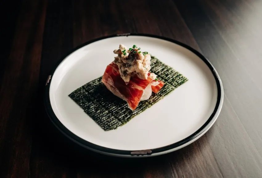 A small appetizer of diced tartare on a crisp black wrapper
