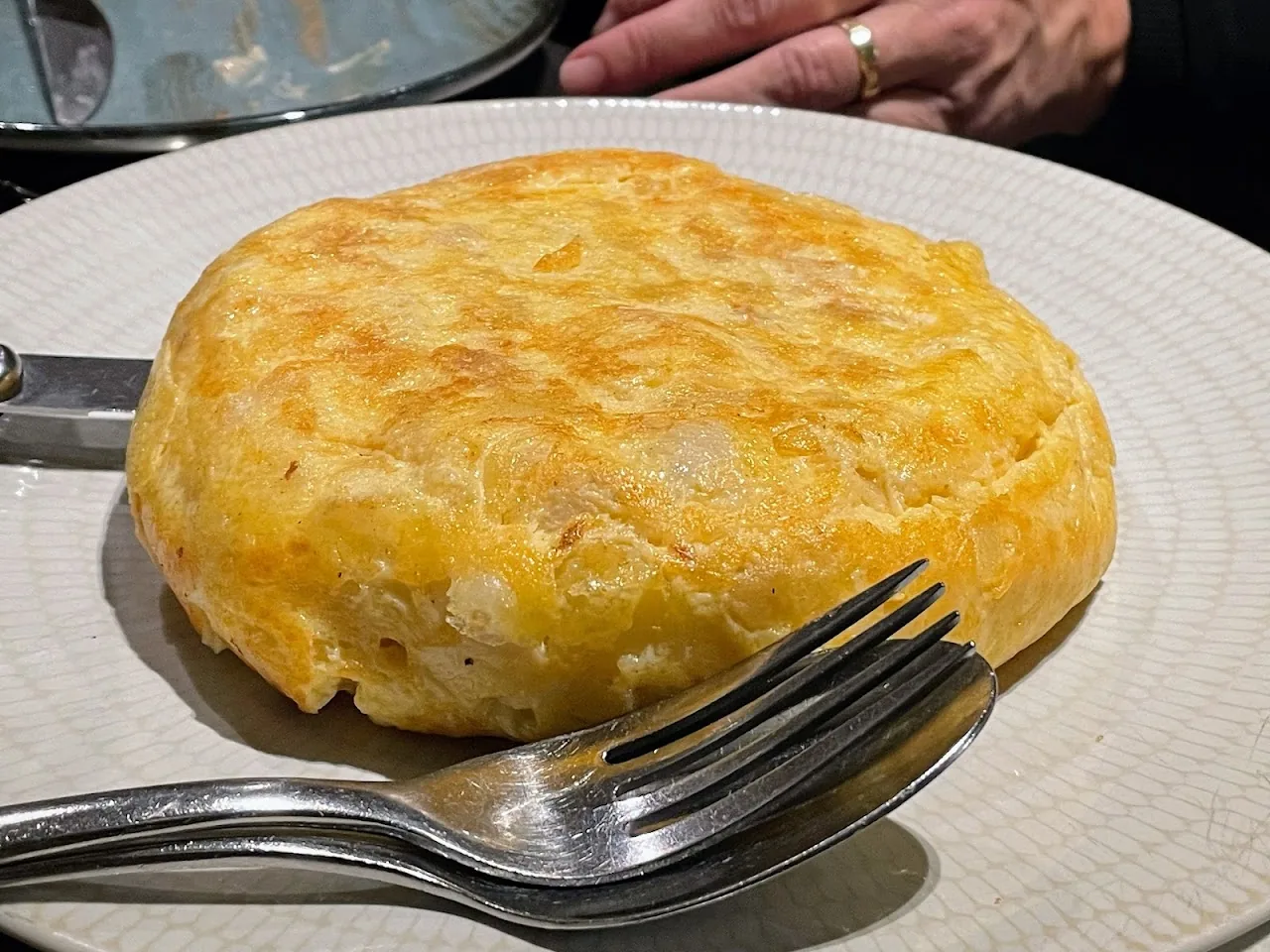 A Spanish tortilla omelette on a plate with a fork