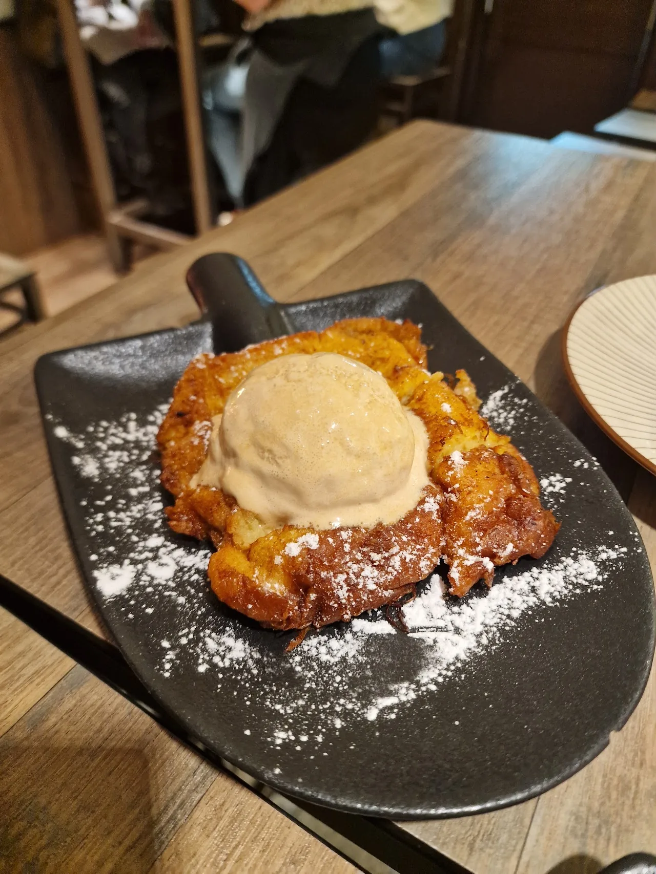 A torrija dessert topped with a scoop of ice cream