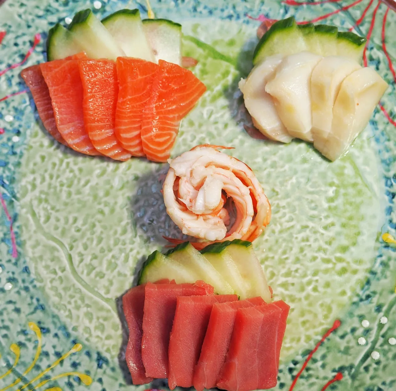 A platter of assorted sashimi including salmon, tuna, and shrimp arranged on ice