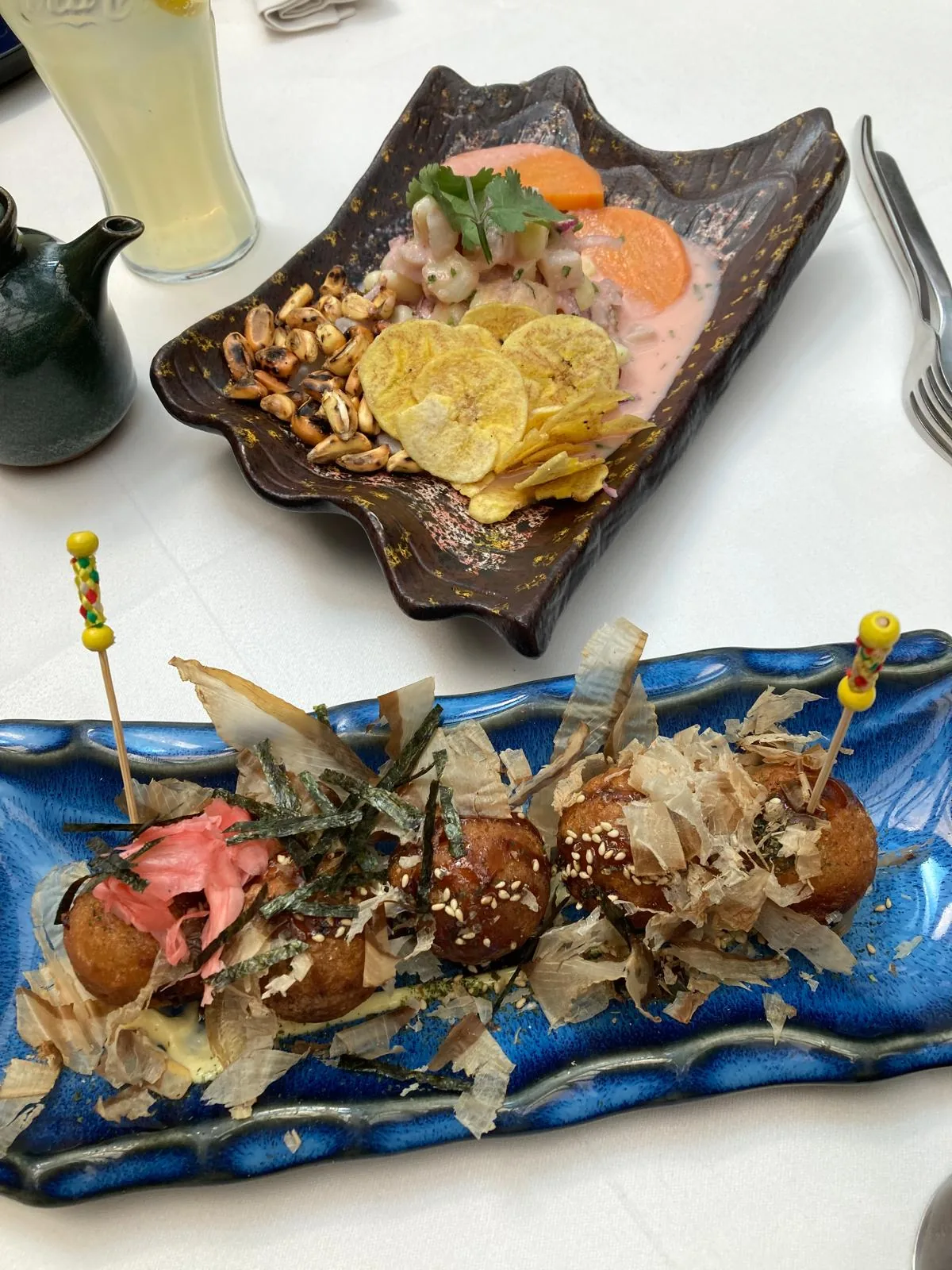 A wave-shaped plate with a poke-style dish garnished with crispy toppings