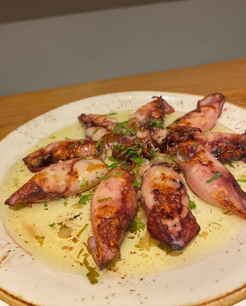 Grilled baby squid drizzled with olive oil and herbs