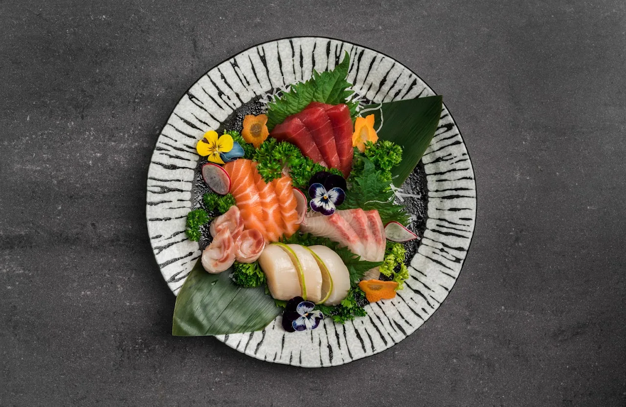 A plate of assorted sashimi garnished with edible flowers