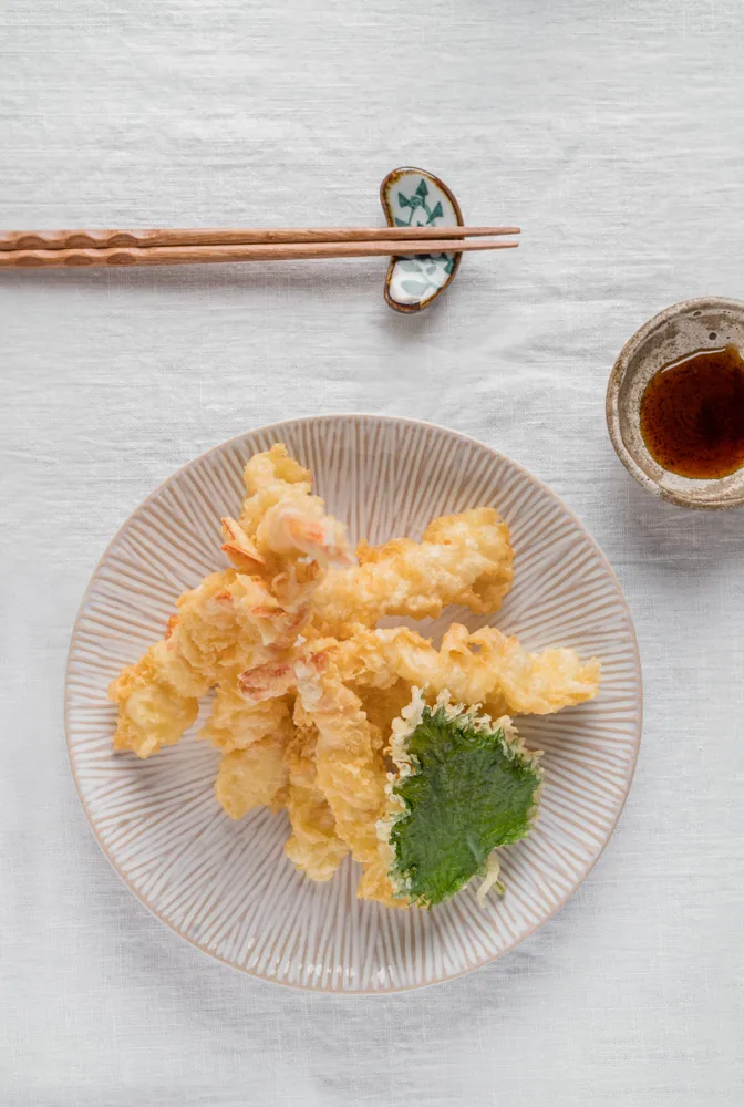 A plate of tempura with dipping sauce