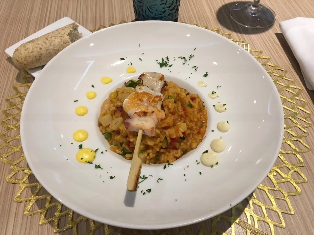 A plate of seafood rice garnished with herbs