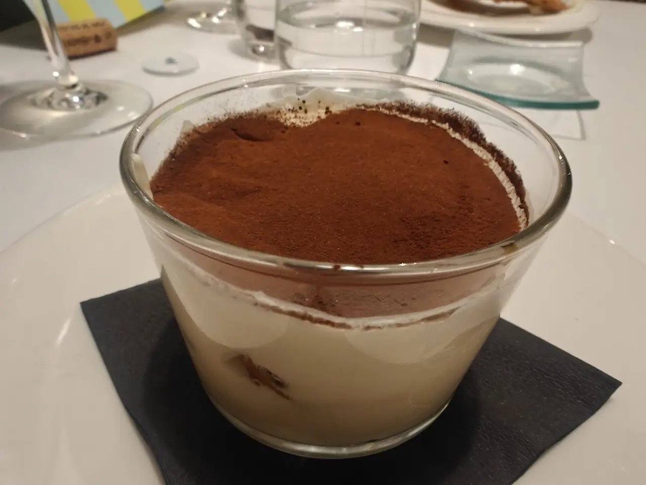 Tiramisu served in a glass, dusted with cocoa powder