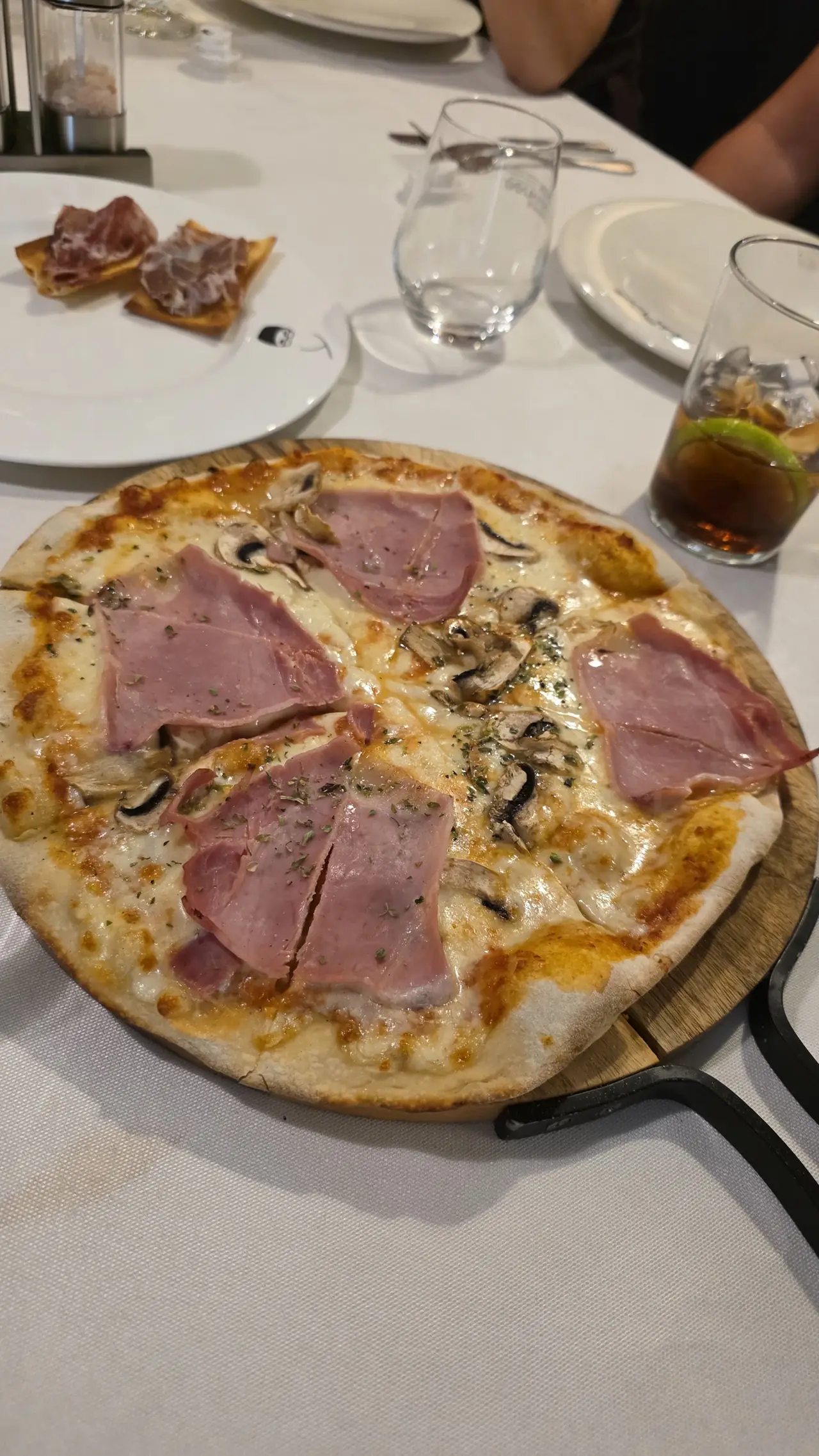 Pizza topped with melted cheese, mushrooms and folded ham slices, cut into quarters