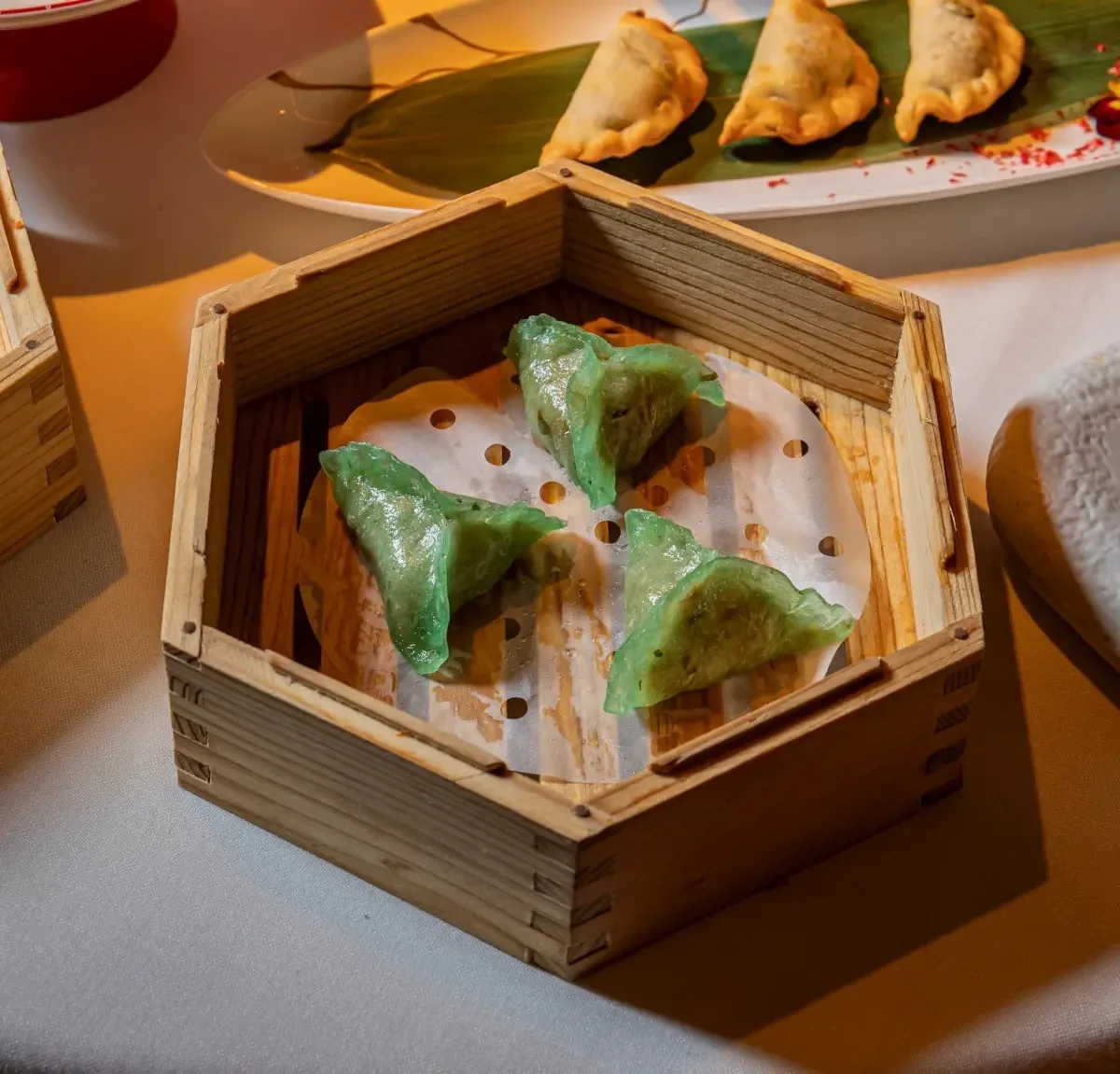 Green dumplings in a wooden steamer basket