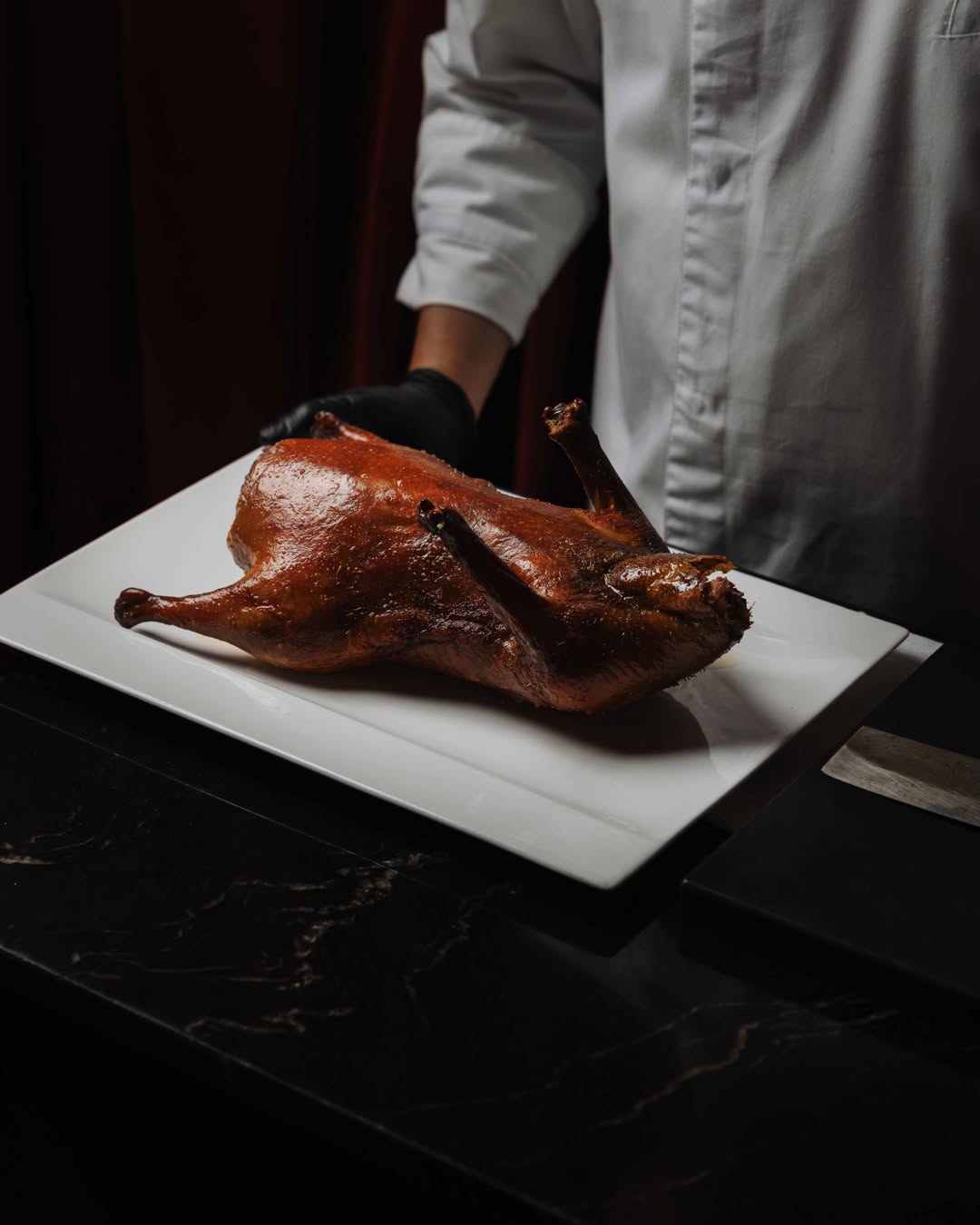Nuestro pato laqueado tiene su propio lenguaje. Crujiente por fuera, jugoso por dentro, con obleas, salsas, y si lo dese