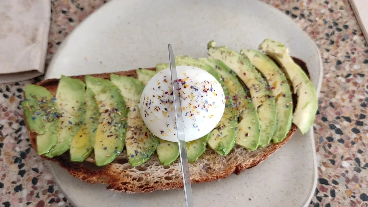 Avocado toast topped with a poached egg on sourdough bread