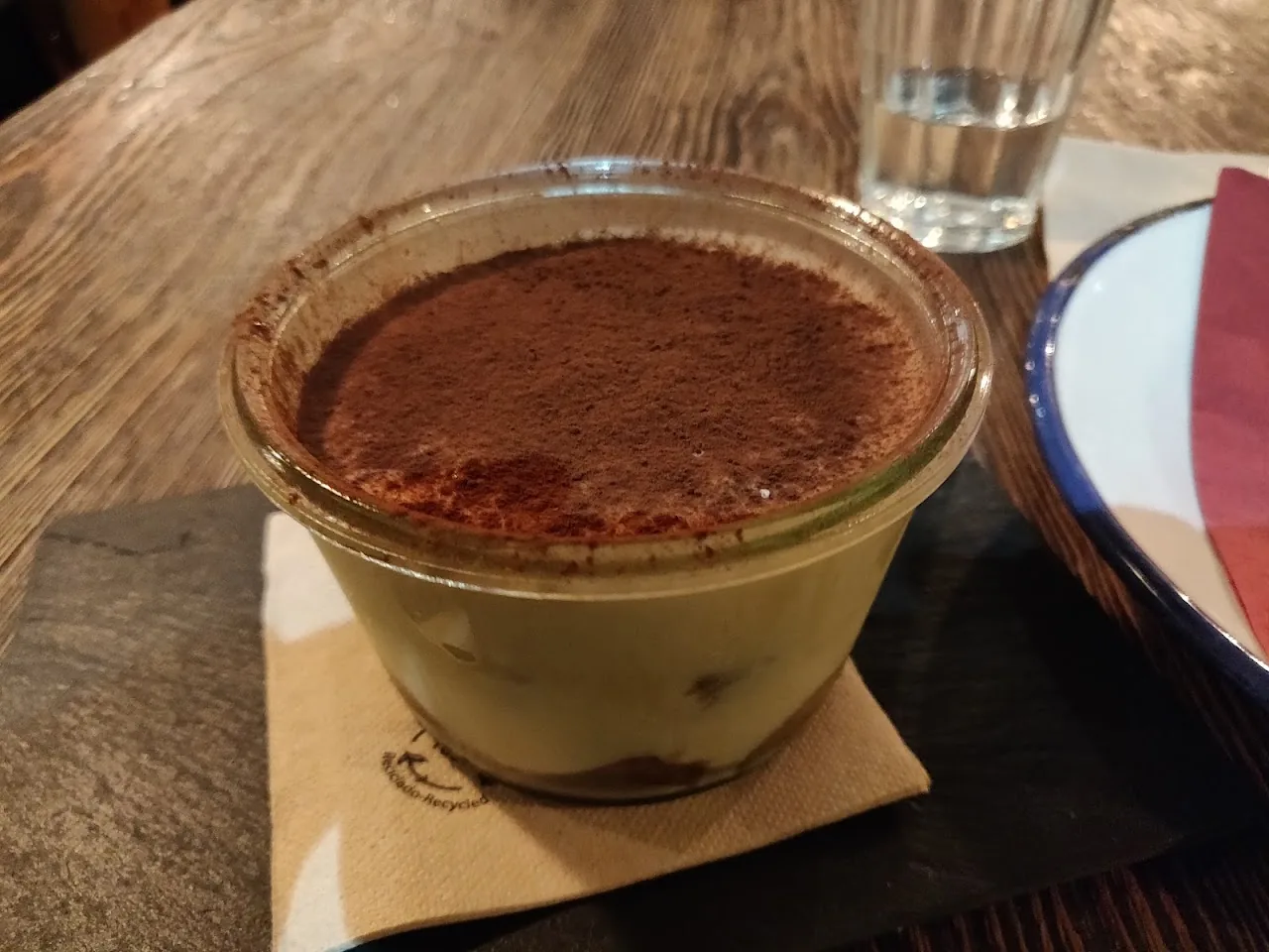 A glass of tiramisu dusted with cocoa powder