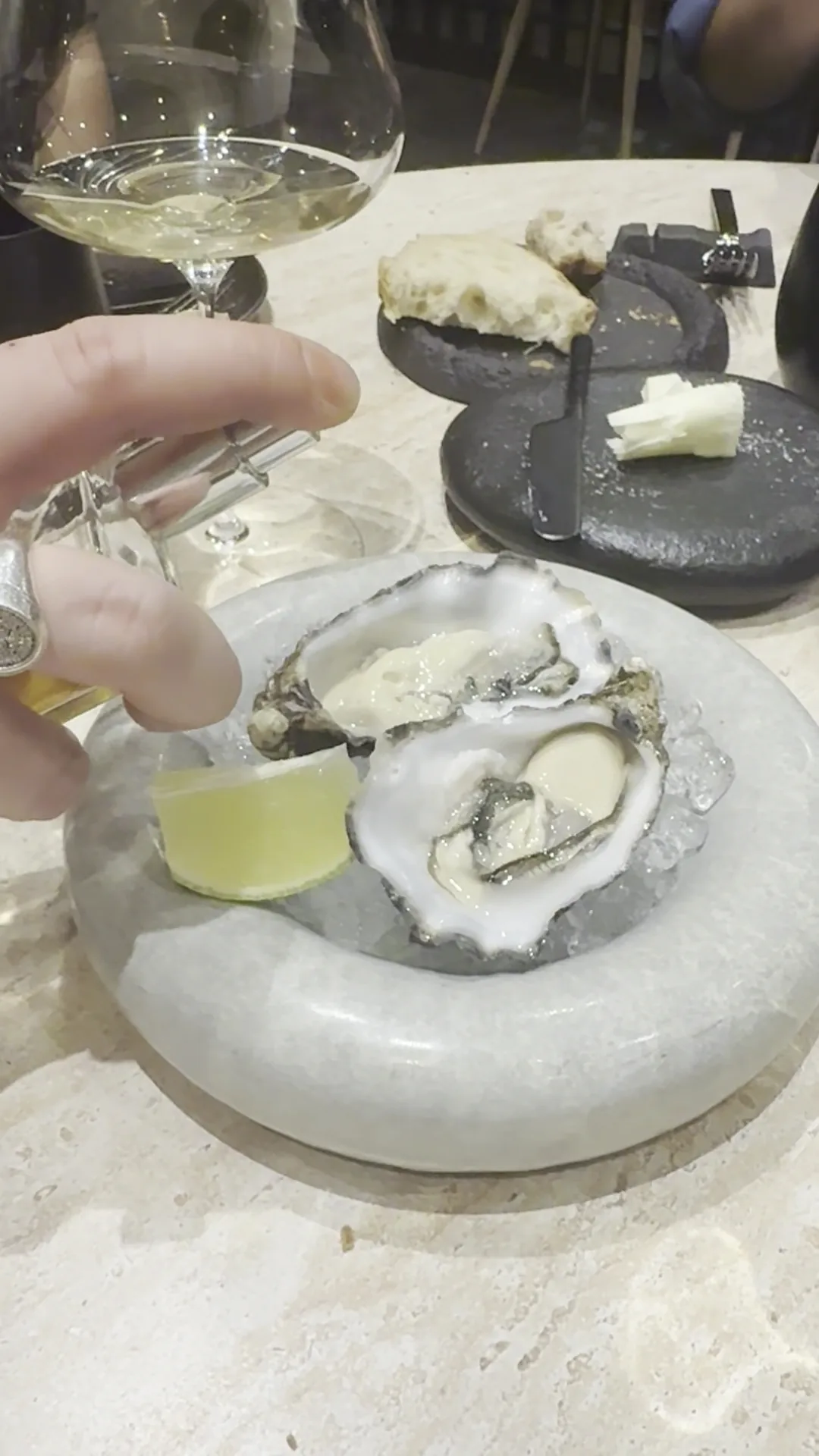 A plate of oysters on ice with a slice of lemon