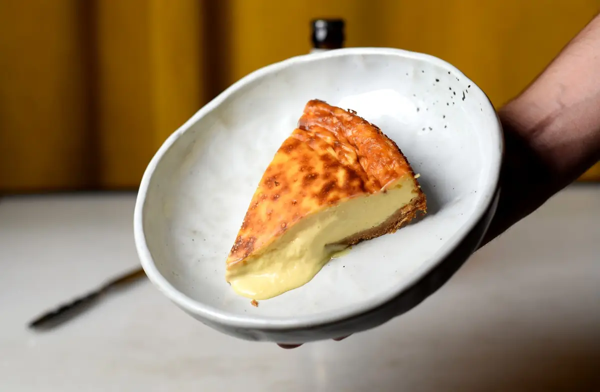 Wedge of Spanish tortilla (potato omelette) on a plate, held in hand