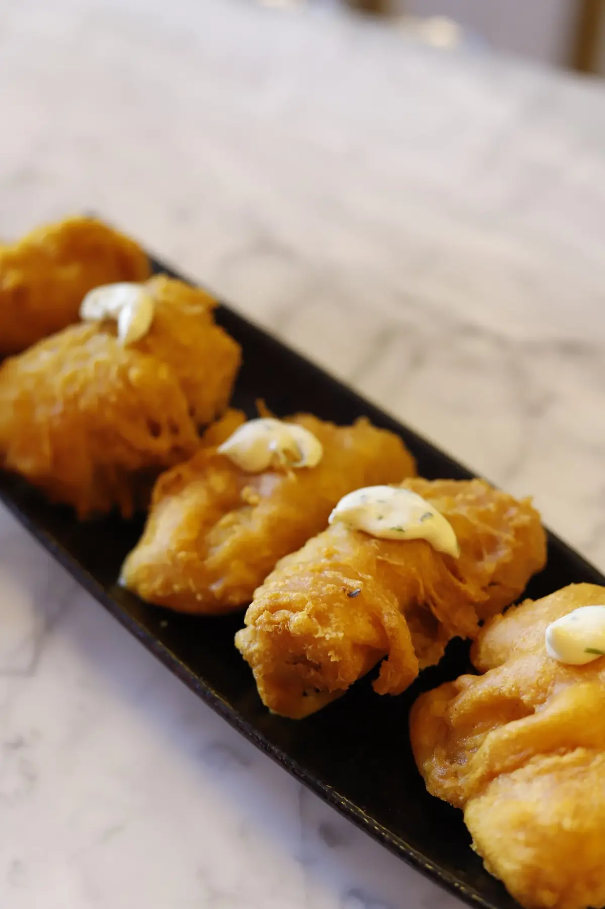 Breaded croquettes on a black plate