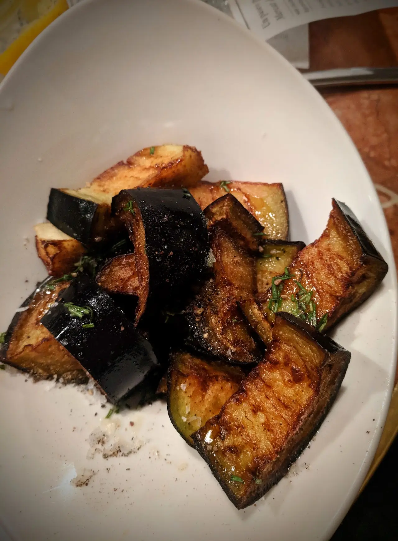 Fried aubergine cubes on a white plate, at El 58.
