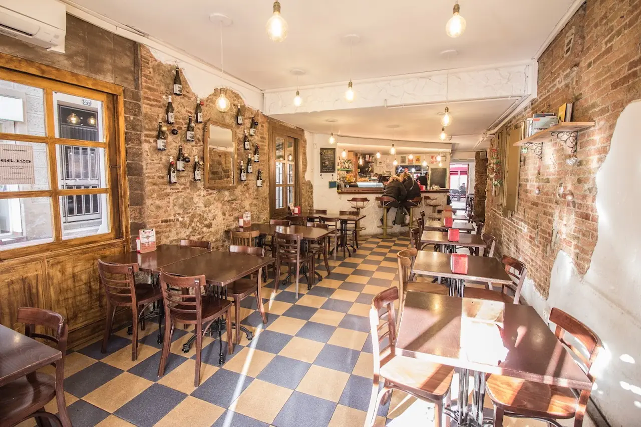 Dining room with a checkered floor, exposed brick walls and bentwood chairs at El 58.