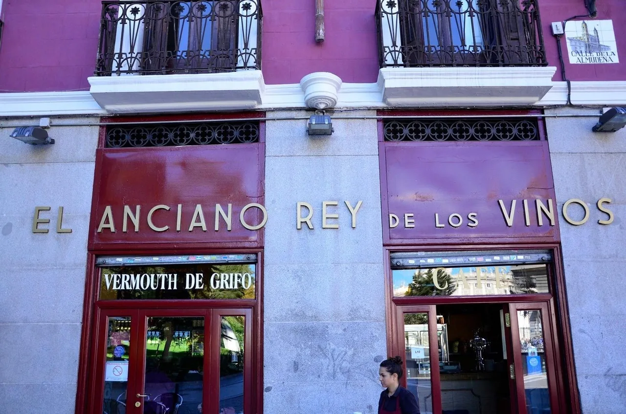 A building frontage painted red with lettering across the top and a doorway below.