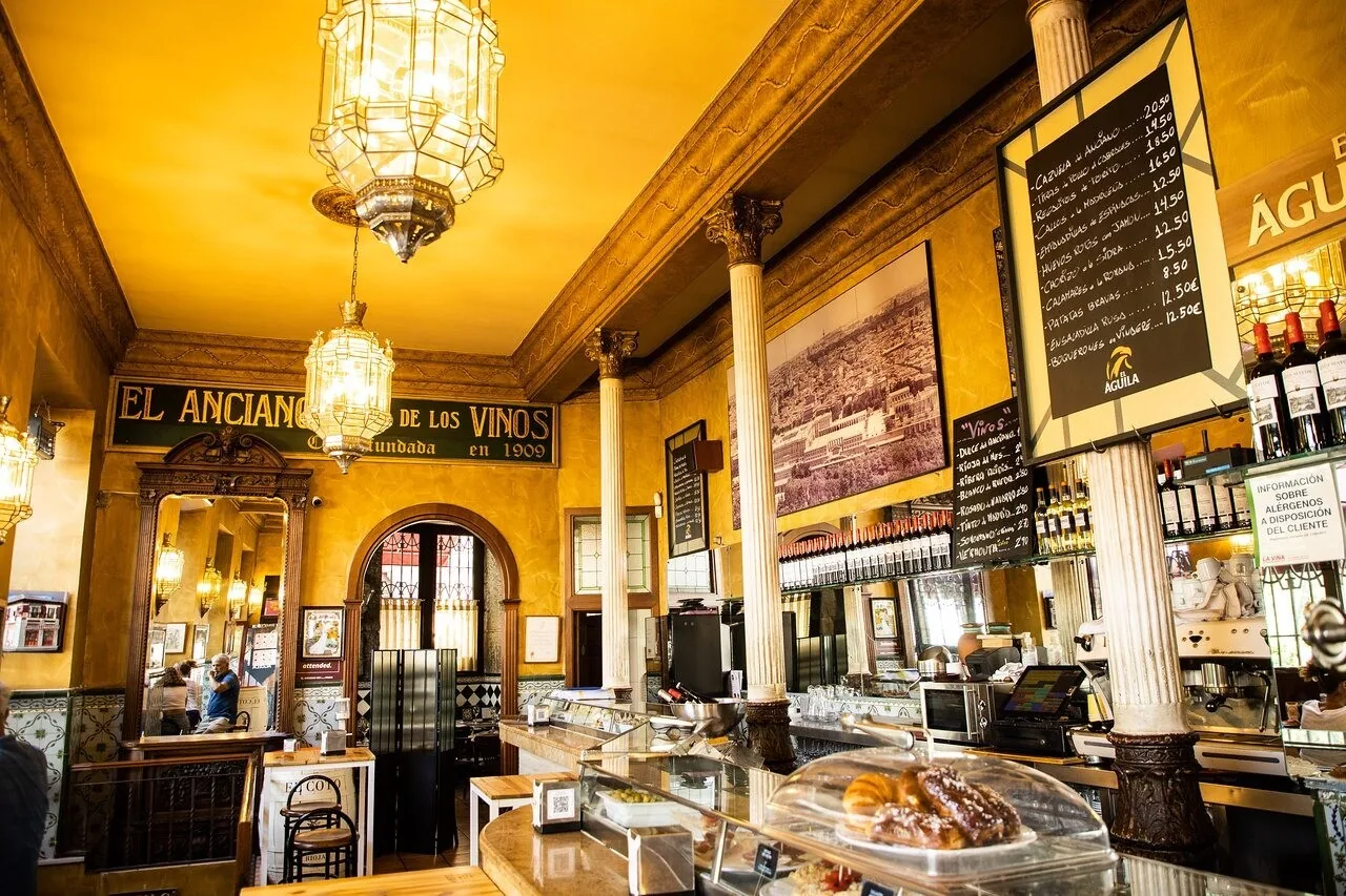 A warmly lit interior with a lamp hanging over a counter and chalkboard menus on the walls.