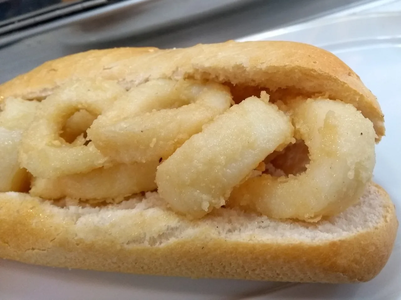 A bread roll filled with battered squid rings.