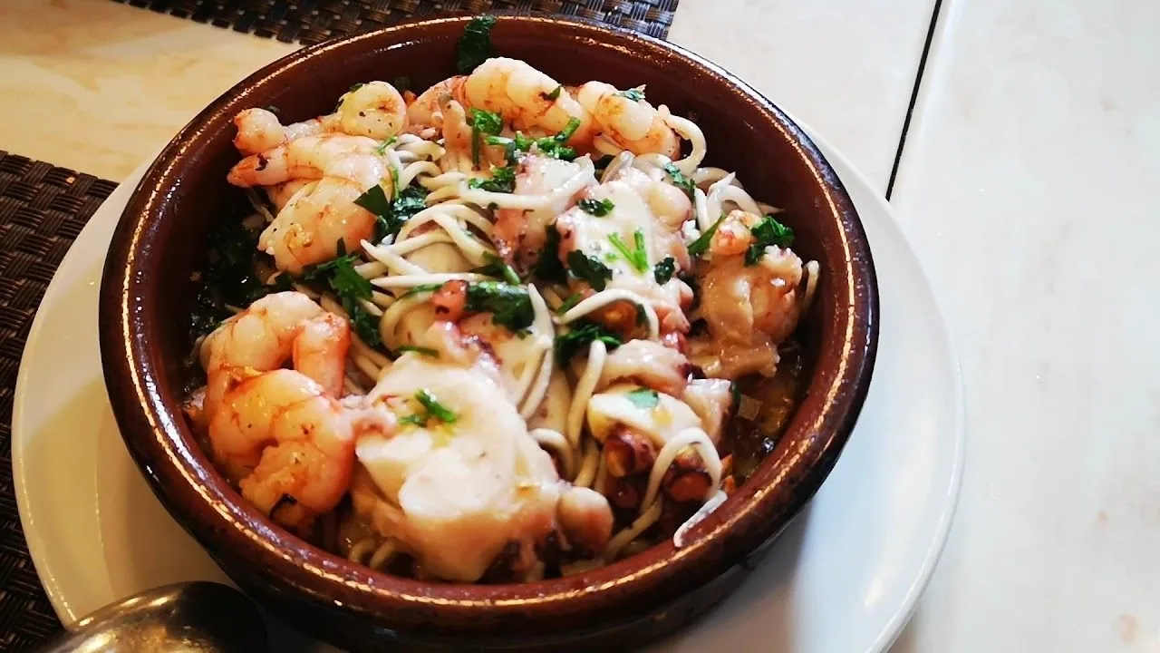 Small prawns with garlic in a brown earthenware dish