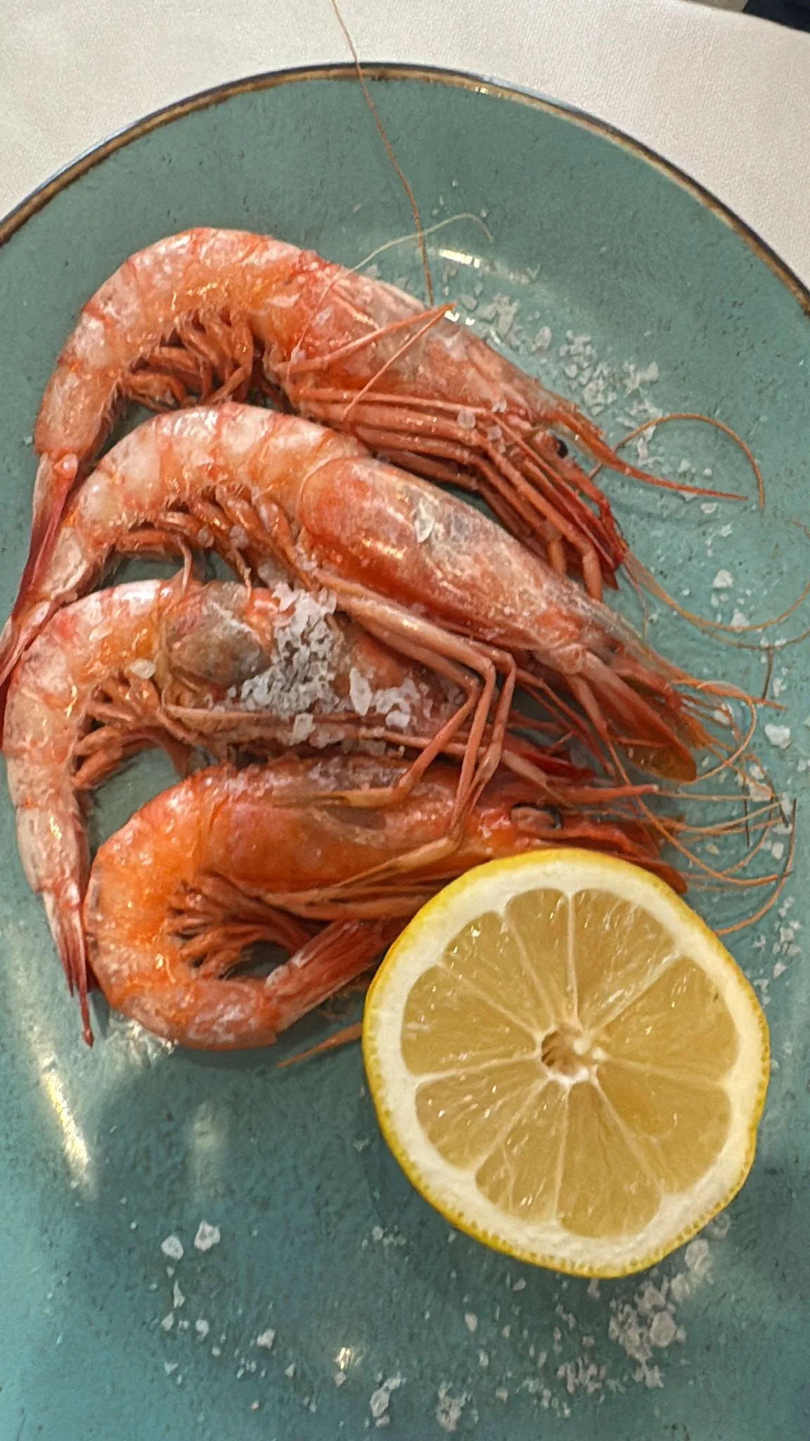 Grilled langoustines with a lemon wedge on a plate
