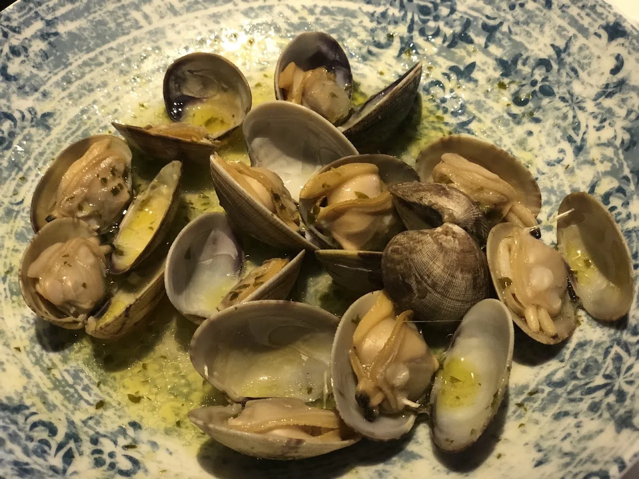 A bowl of steamed clams in green sauce